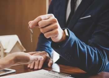 Real estate agent Sales manager holding filing keys to customer after signing rental lease contract of sale purchase agreement, concerning mortgage loan offer for and house insurance