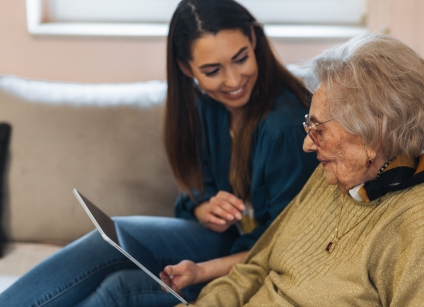 Grandmother and granddaughter looking at pictures on tablet.