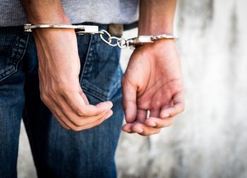 Close up hands tied up handcuffs in behind his body. Arrested ma