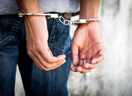 Close up hands tied up handcuffs in behind his body. Arrested ma